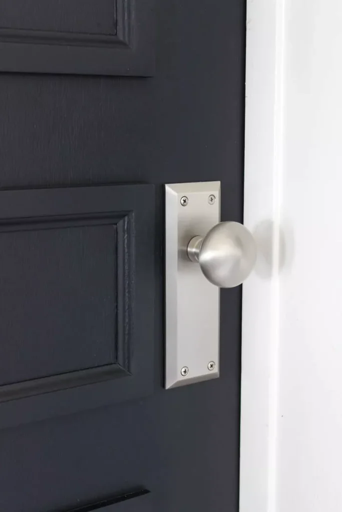 basic chrome doorknob panel on a black door