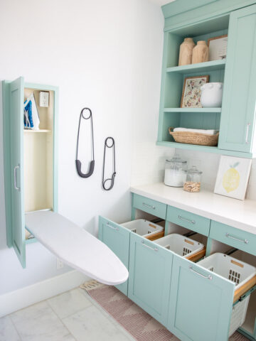 blue mounted cabinet with a pull out ironing board