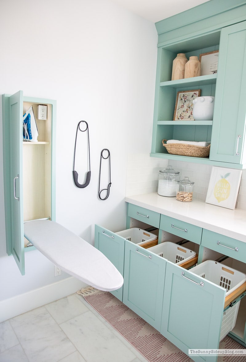 blue mounted cabinet with a pull out ironing board