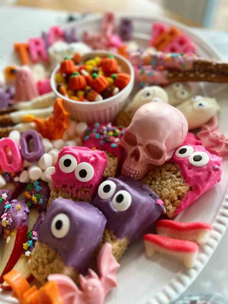 Pink and purple chocolate Halloween snacks piled on a serving tray.