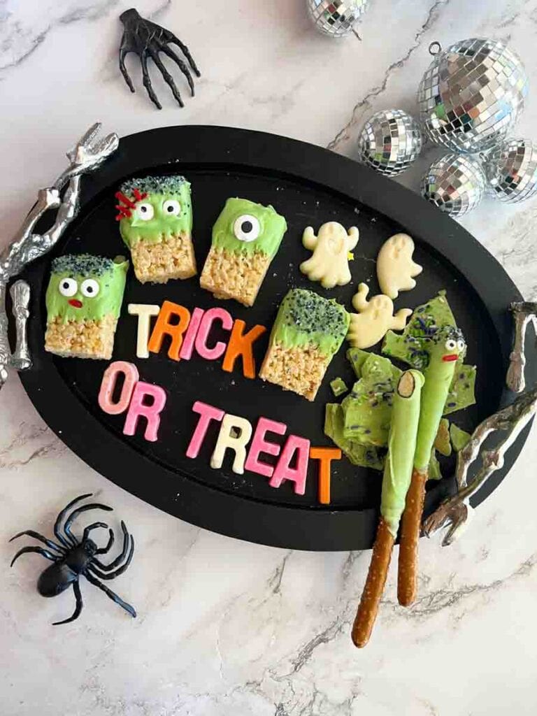 Trick or Treat written out with chocolate candy letters, surrounded by Halloween Rice Krispie treats.