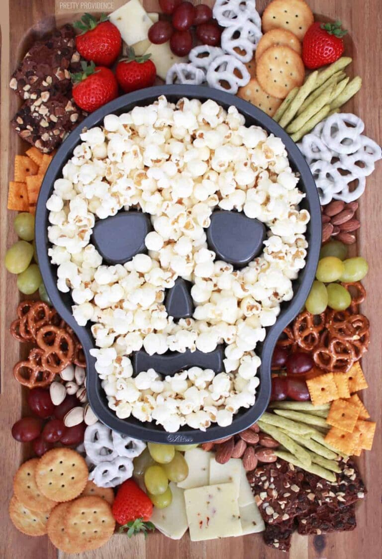 Skull centerpiece filled with popcorn on a charcuterie board