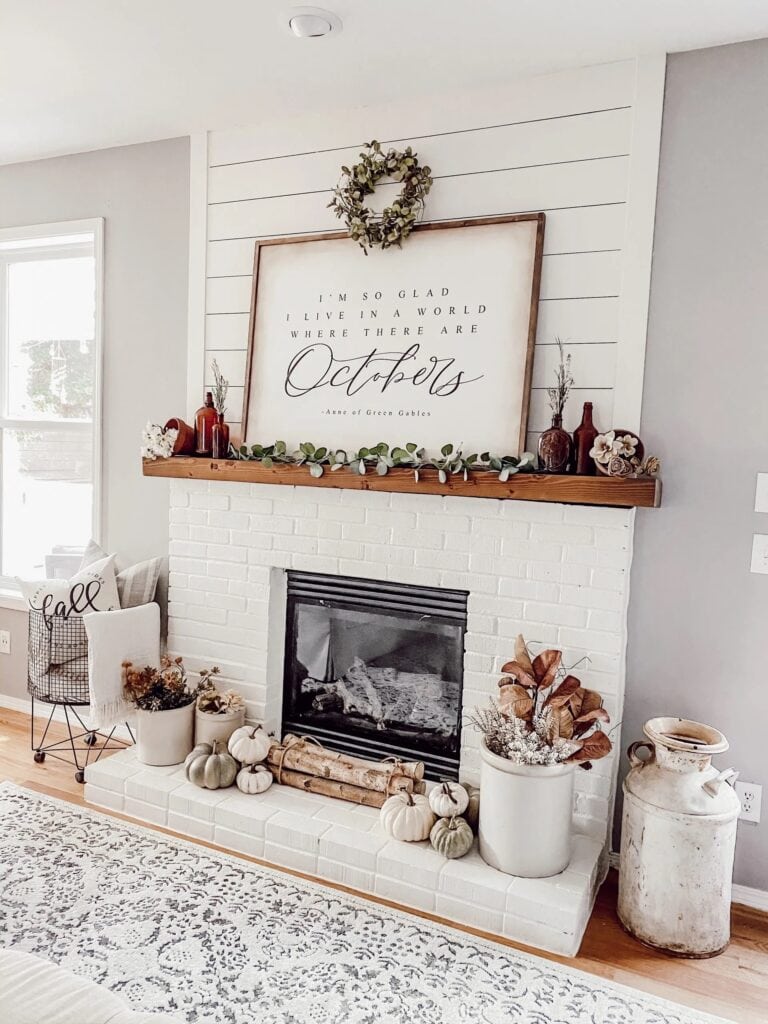 large wood sign on a fall mantel with even height decor on either side