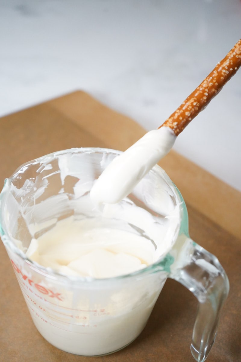 dipping pretzels into melted white candy