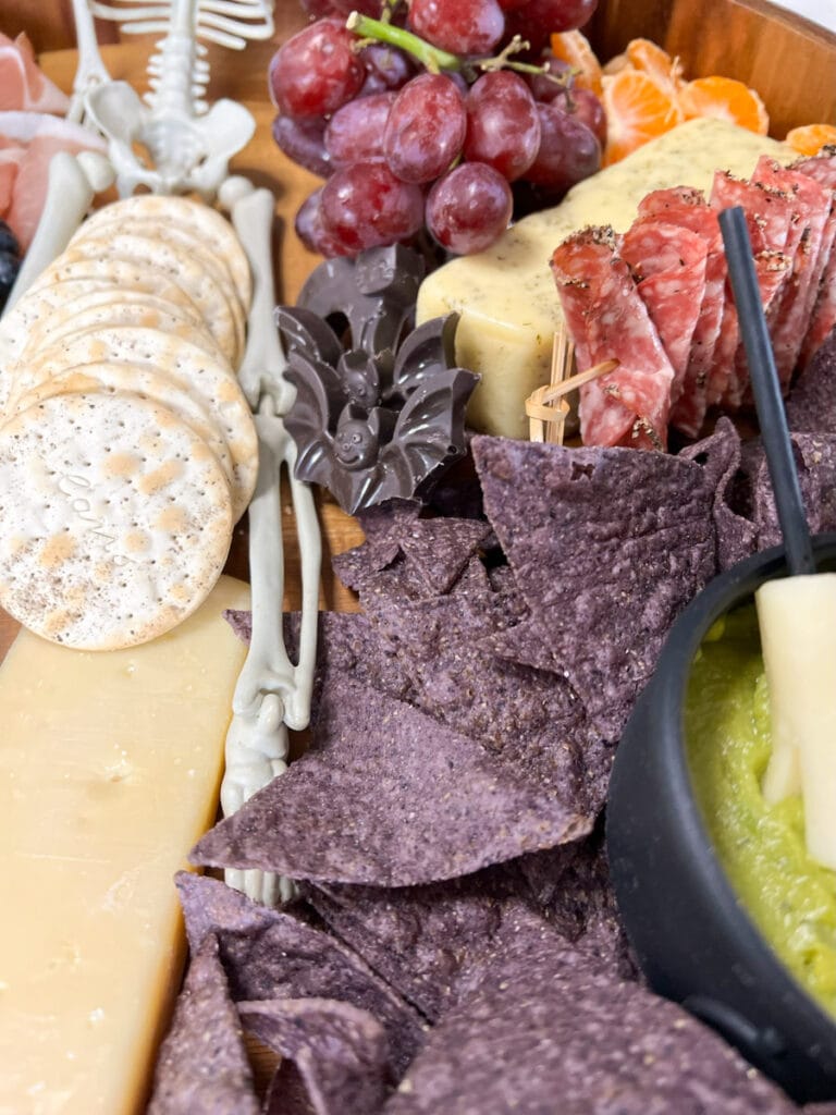 blue corn tortilla chips, cheese broomsticks, chocolate bats, and more on a large snack tray