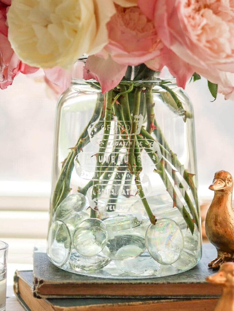 etched glass vase with pink and white roses inside