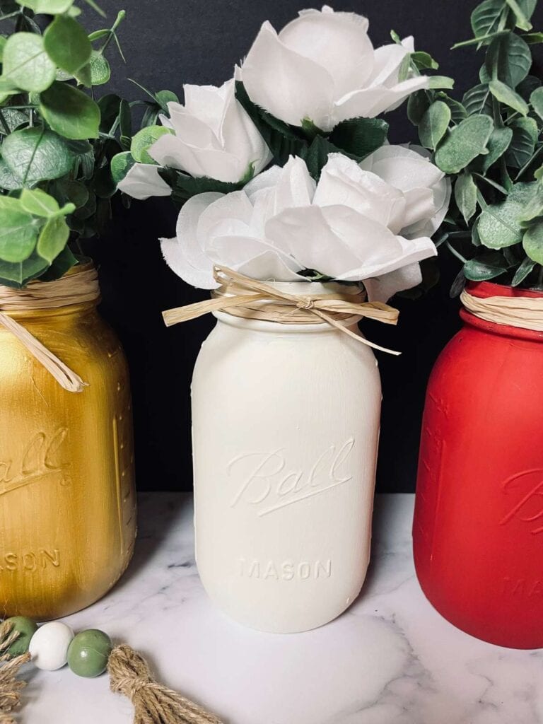 red, cream and gold painted mason jars filled with faux florals