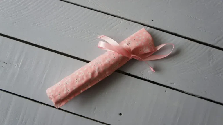 pink fabric storage roll for makeup brushes or tools, tied with ribbon