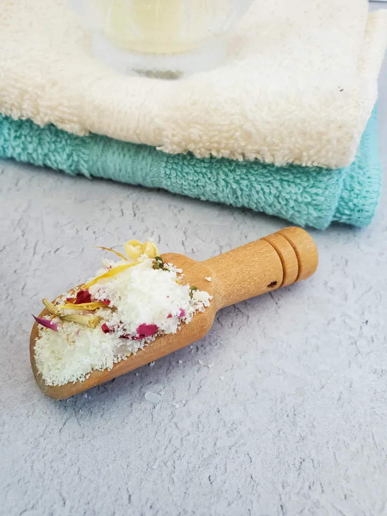 a floral bath soak on a wooden scoop