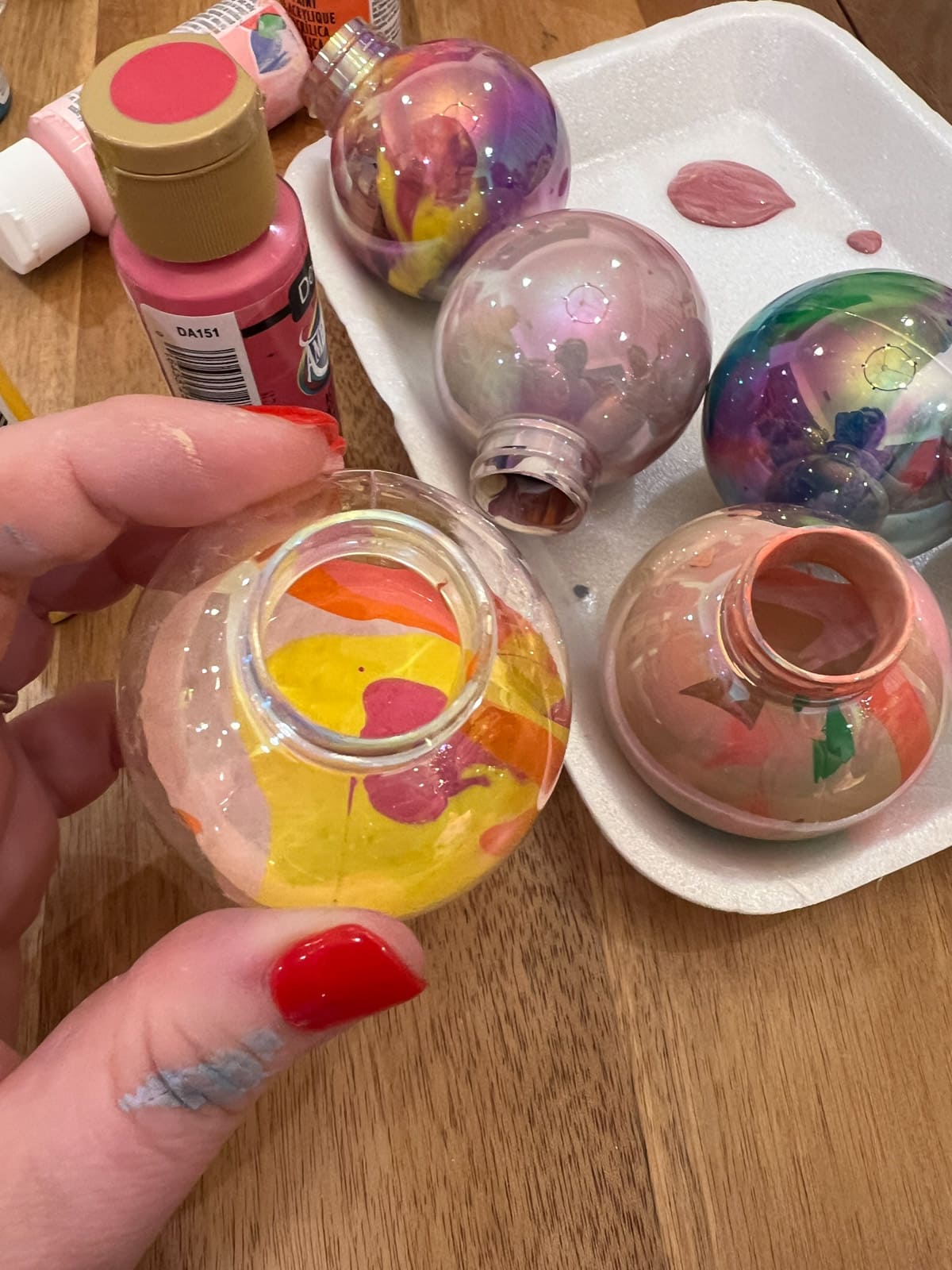 Showing how to make diy painted ornaments using clear ornaments and craft paints.
