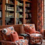 peach color drenched living room with built-in bookshelves and matching arm chairs