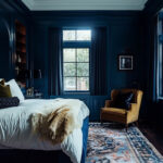Black bedroom with painted paneling and white ceilings.