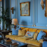 a color drenched living room painted dusty cornflower blue with monochromatic painted paneling