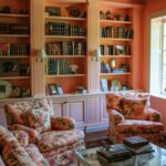 Color drenched pink living room with a wall of bookshelves and pink matching armchairs and sofa.