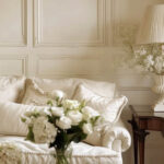 Monochromatic cream painted living room with cream sofa, accents, and flowers.