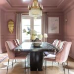 Color drenched pink muave dining room with abstract art and fresh flowers.