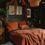 boho rust colored linens on a large bed, in a room painted black