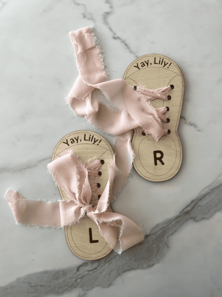 Laser cut wooden shoes with ribbon to practice tying shoes.