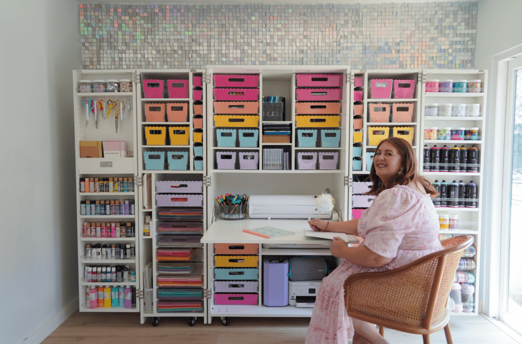 Woman smiling and writing with a pen in front of the Dream Box by Create Room