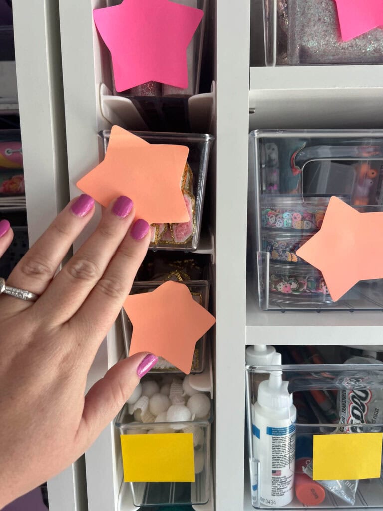 sticking colored stars to clear totes