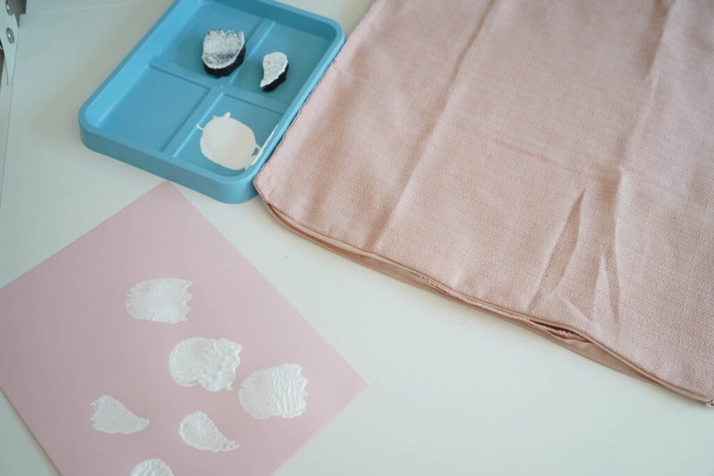white paint on a tray next to pillowcase