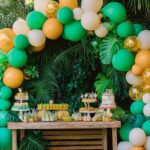 table beneath an arch of jungle themed balloons