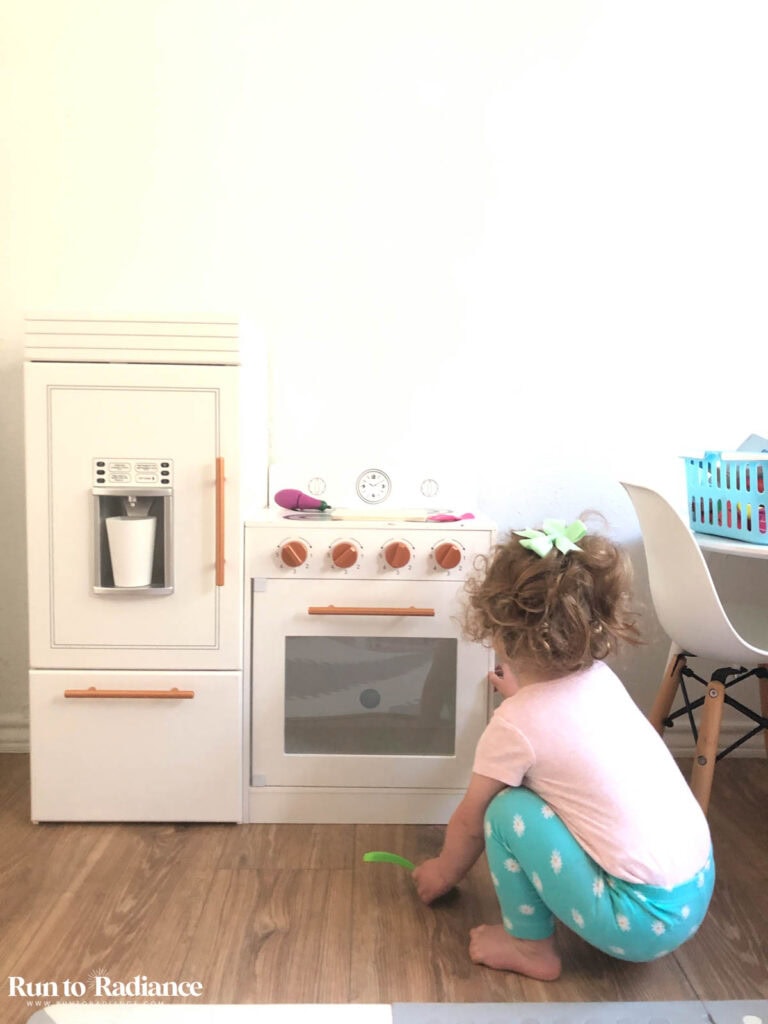 little girl with play kitchen