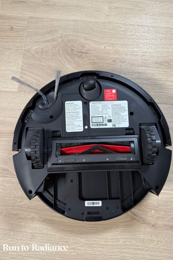 Roborock Q7 L5 turned upside down showing main brush, side brush, and sensors.