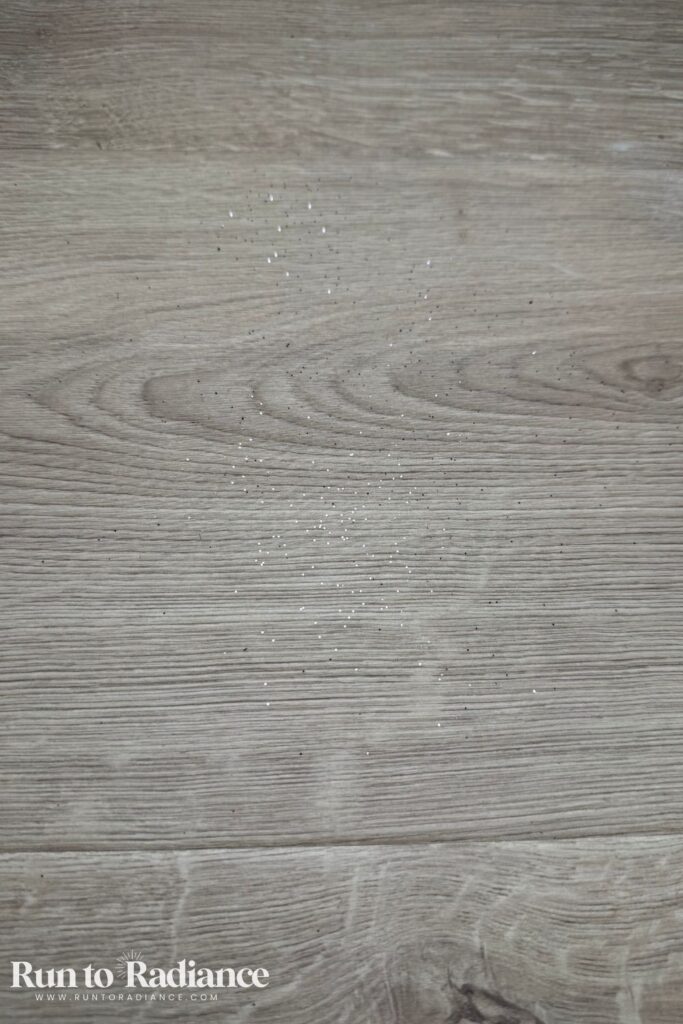 Glitter on a wood floor before vacuuming