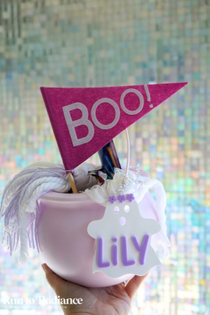woman holding up a pink boo basket with a purple tag and pink flag