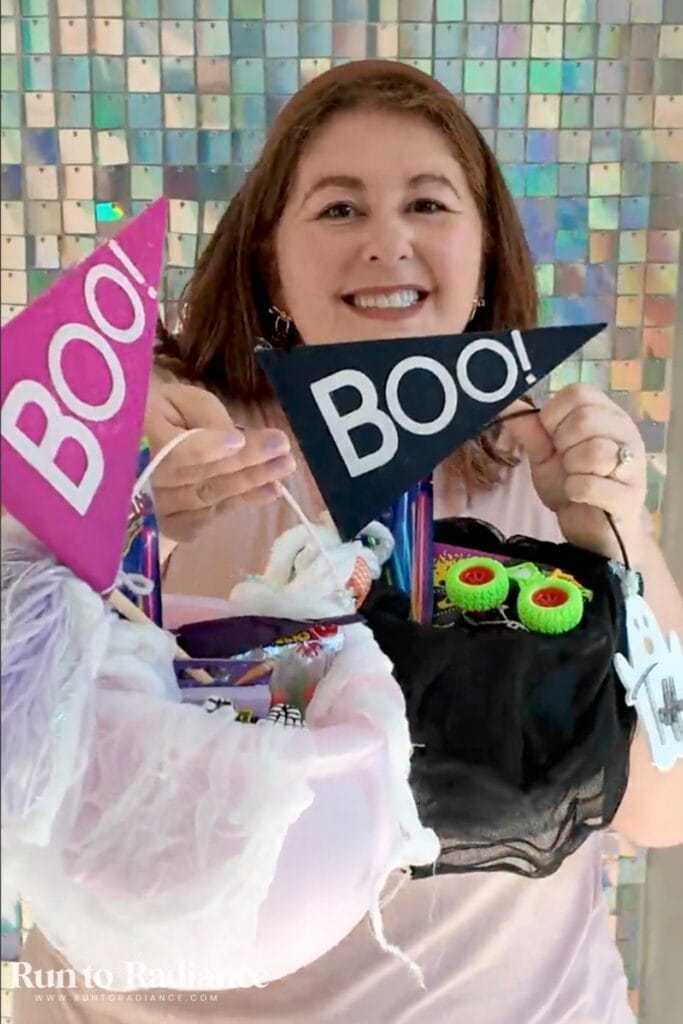 woman holding up 2 boo baskets for kids