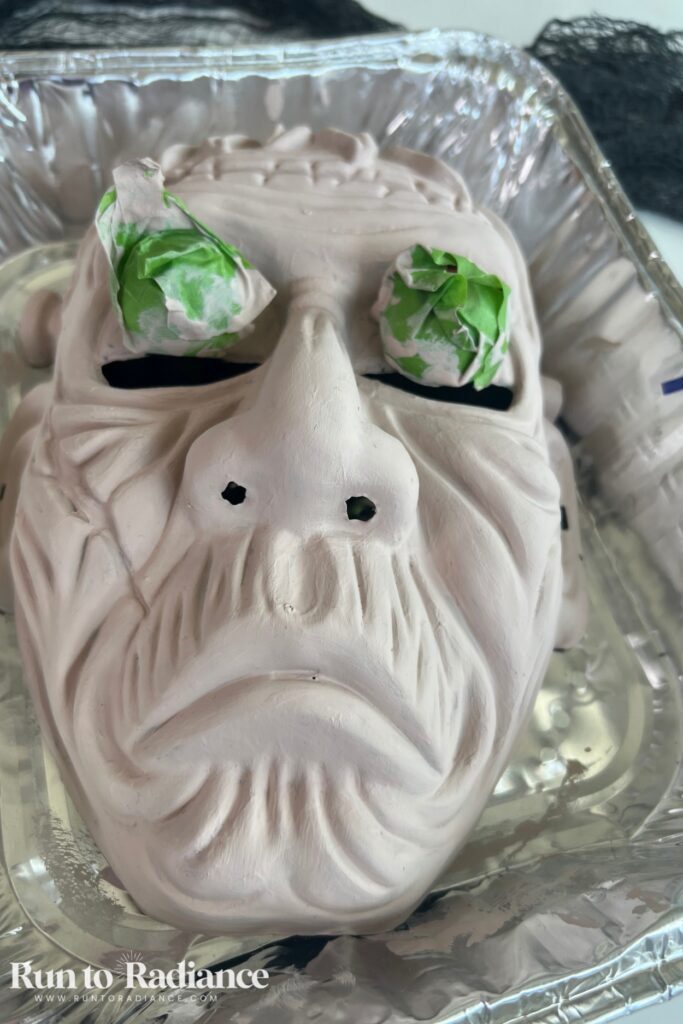 Painting a halloween mask white for a spooky face centerpiece craft