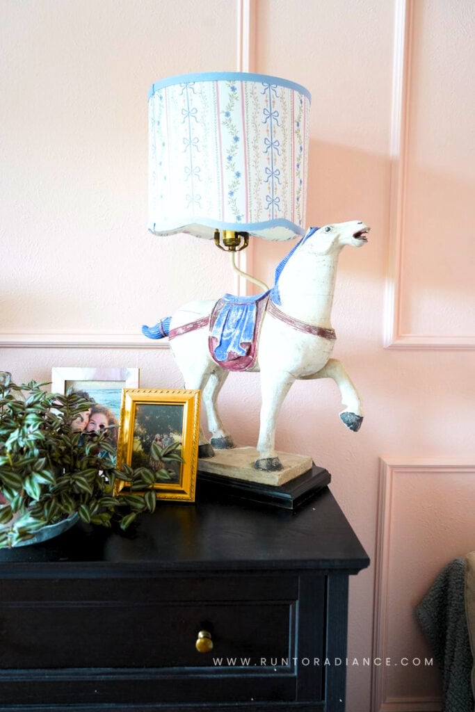 Vintage horse lamp styled on a dresser with framed family photos, cottagecore whimsy