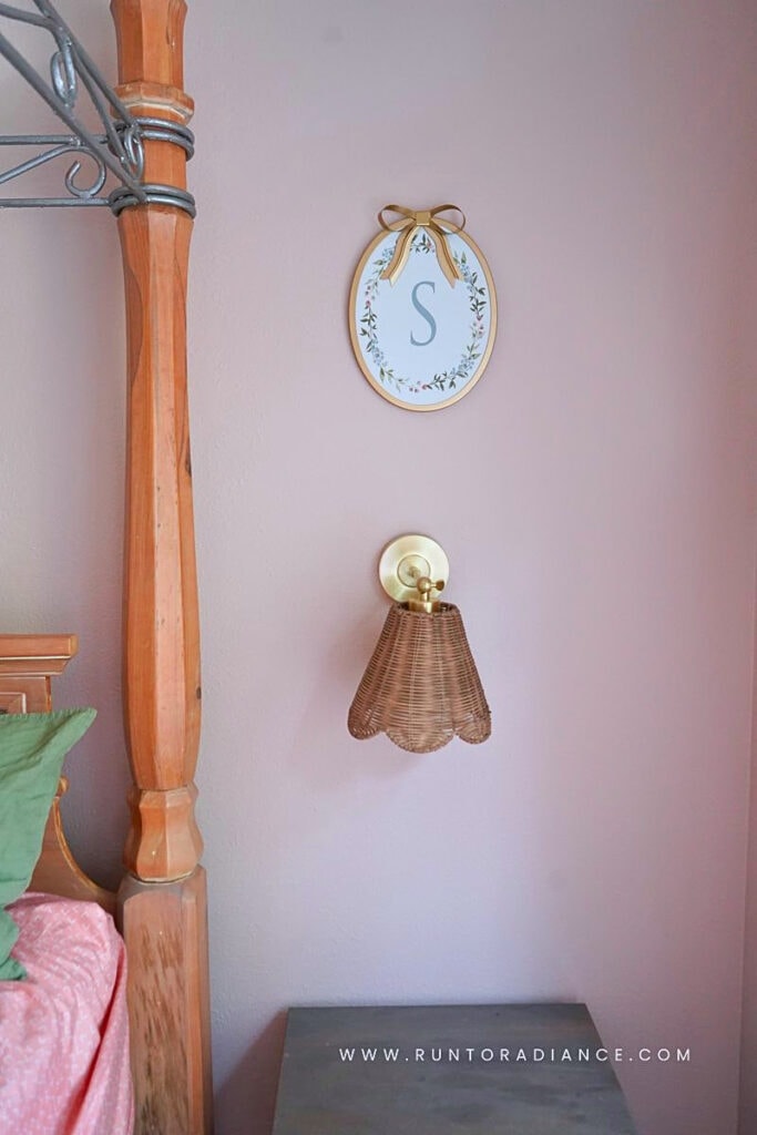 Pink cottagecore bedroom corner with a four-poster bed and rattan hanging light