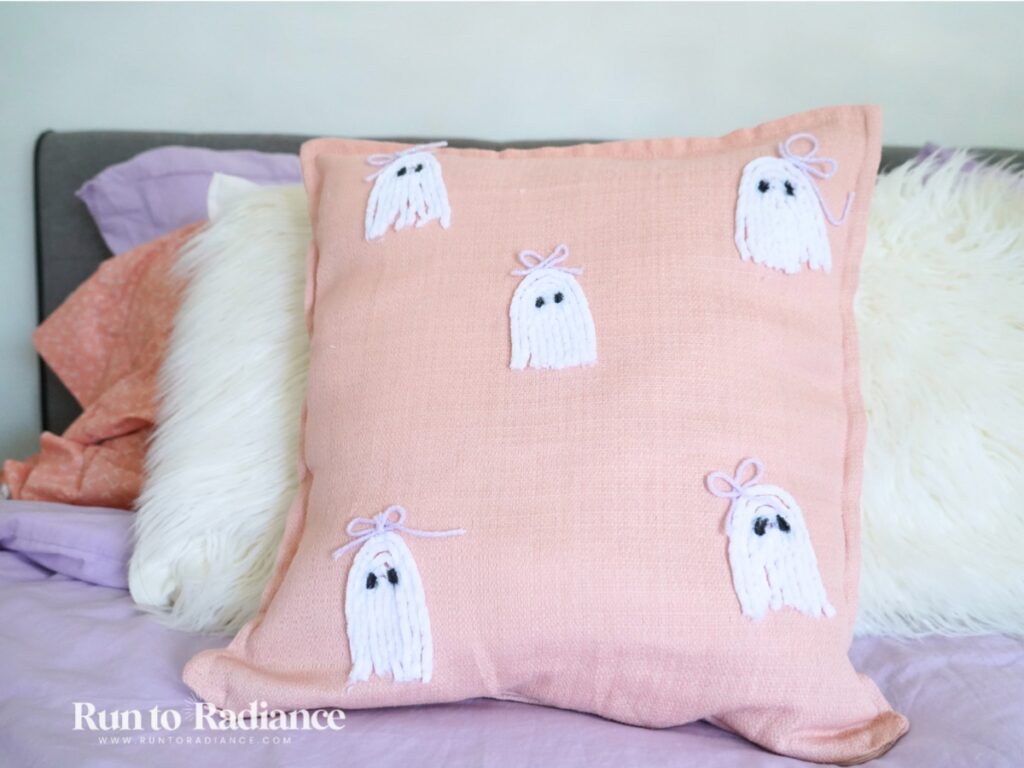 close up of a pink diy ghost pillow made with yarn