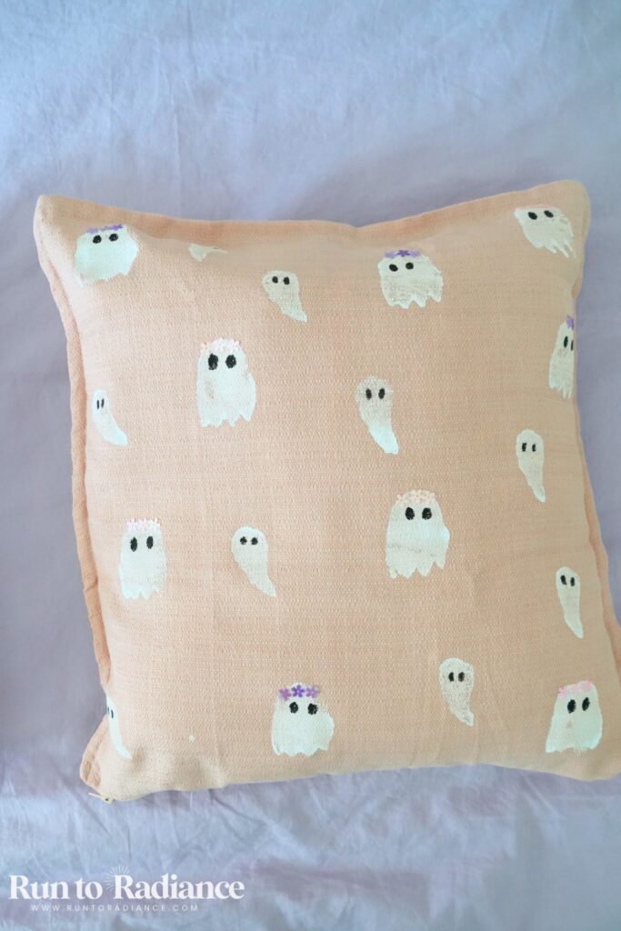 painted ghost pillow on a bed