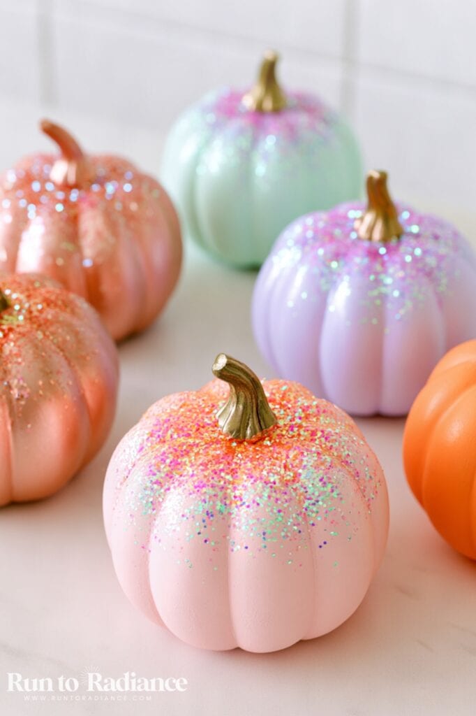 pastel painted pumpkins in orange, copper, mint, blush, and lavender topped with glitter