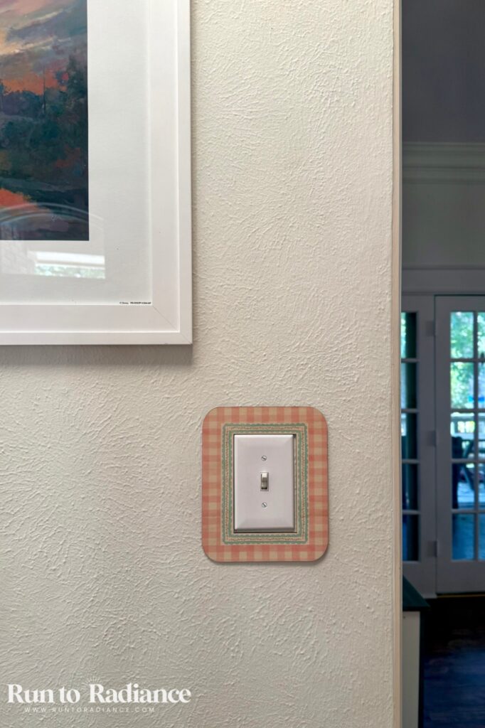 diy lightswitch cover on the wall next to a painting